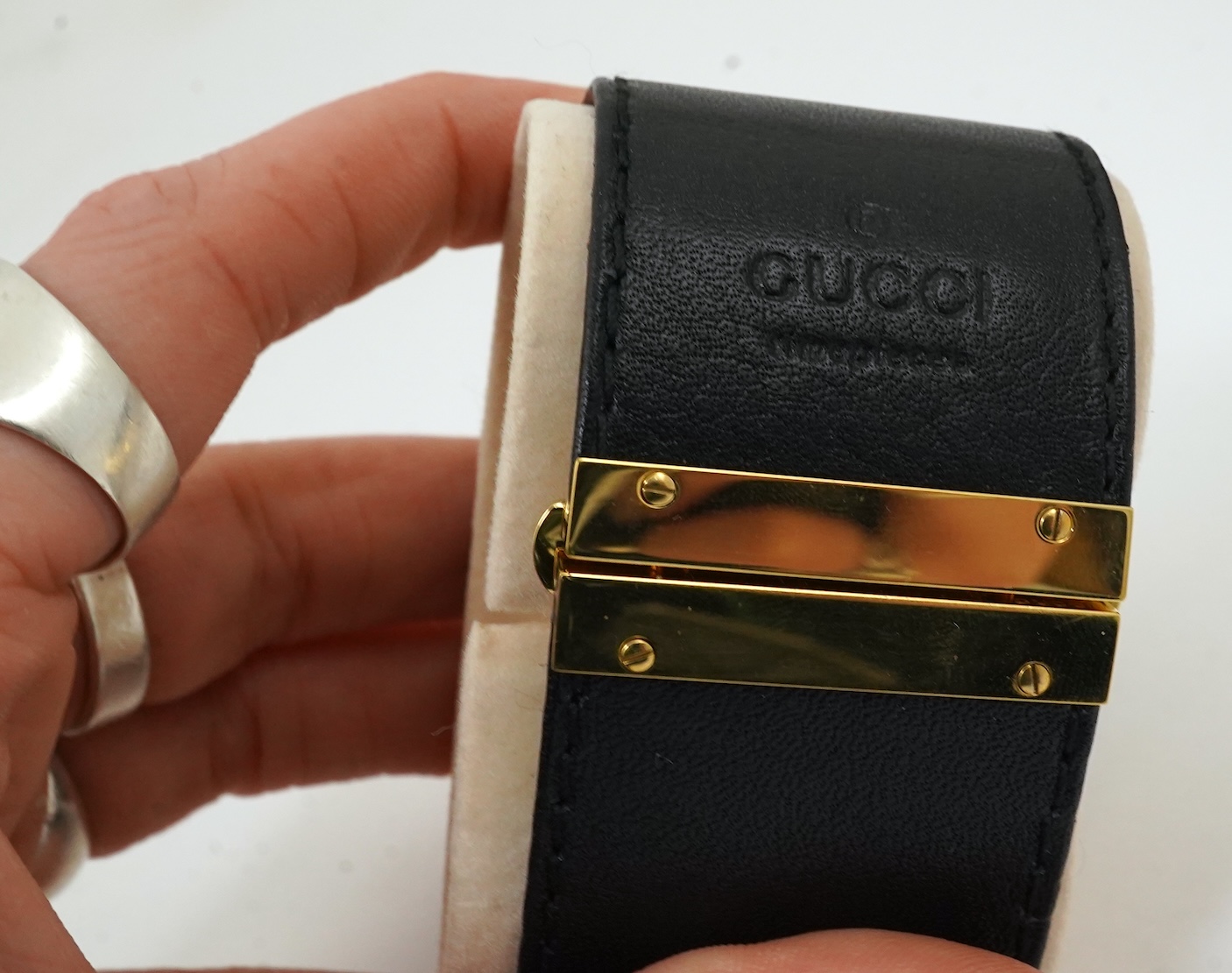 A lady's Gucci watch with wide leather strap, with box and papers.